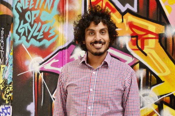 Kunal Khanna, standing in front of a wall covered in street art
