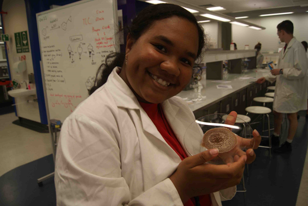 Student posed with biological sample on a slide.