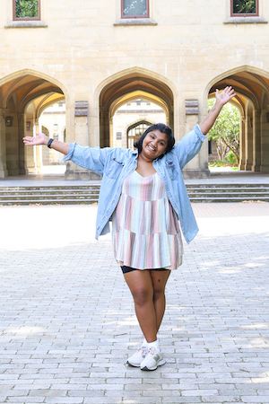 An excited student celebrating in front of the iconic Old Quad building