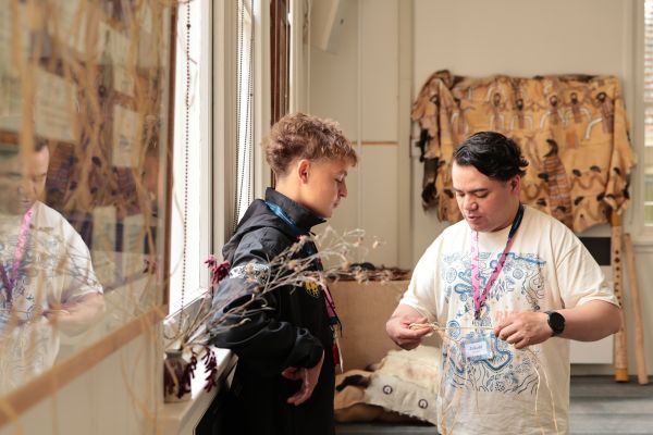 RISE mentor shows participant how to weave raffia