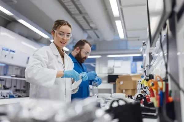 Two people in lab coats working in a lab