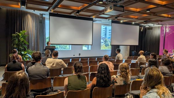 The Dean of Science standing at a podium; the screens nearby are blank