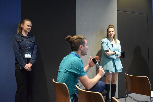 An audience member asking a question, with the session chair and speaker looking on
