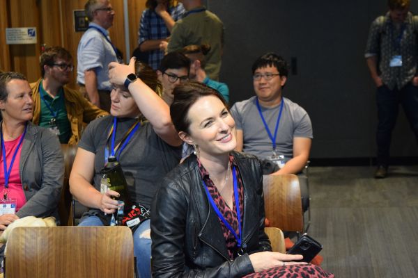 Audience members (seated and standing) talking