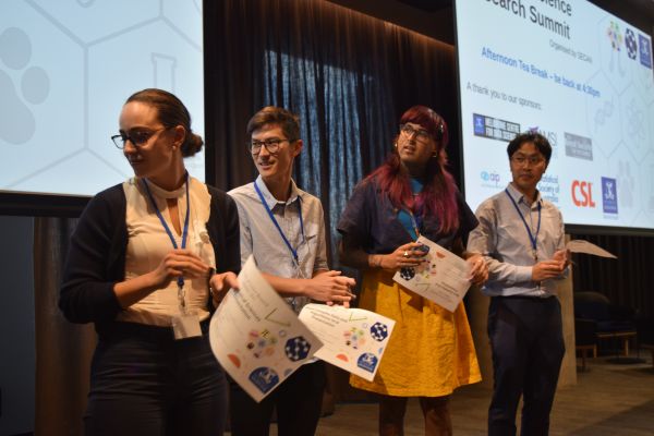 Several speakers with certificates standing side-by-side