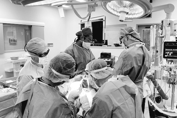 A black and white photo of five people taking part in a surgical procedure