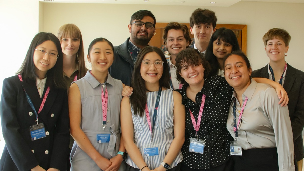 A diverse group of eleven young people indoors