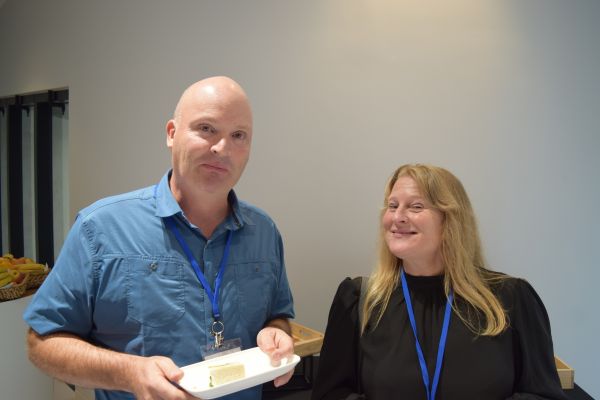 Two conference attendees, one holding a plate of food