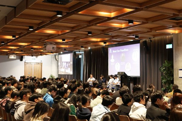 Panel presentation in front of auditorium full of people
