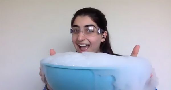 Woman smiing and holding bowl of soapy water