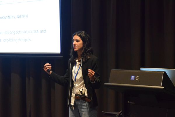 A presenter at the podium and a corner of their slide