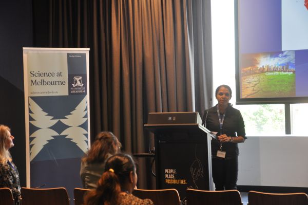 A speaker at the podium; a corner of their slide and a 'Science at Melbourn' banner are visible
