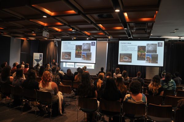 A wide-angle view of a presentation, with the slide title 'Content ideas'. Most of the audience is in frame