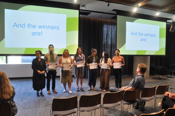 The Dean of Science standing next to speakers holding certificates; some audience members are in frame