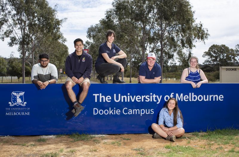 Students sitting in front of the Dookie College sign at the University of Melbourne's Dookie campus