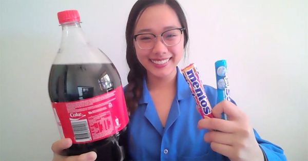 Tina, holding a bottle of Coke and two sticks of Mentos