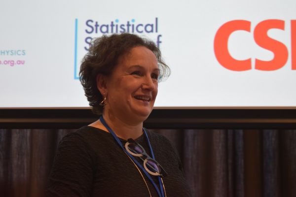 A close-up of Moira O'Bryan (Dean of Science), with the bottom of a slide visible behind