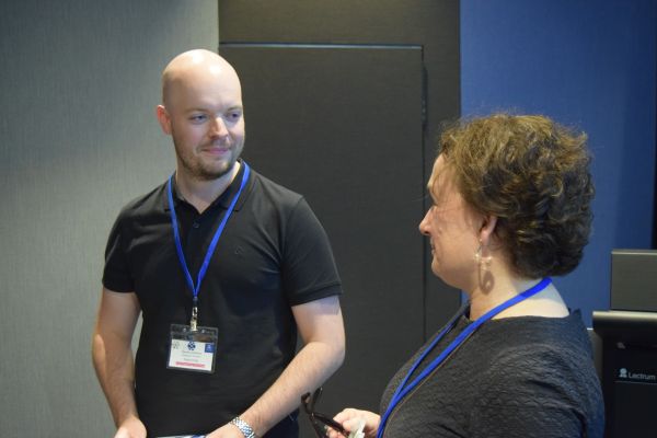 A conference attendee speaking with Moira O'Bryan
