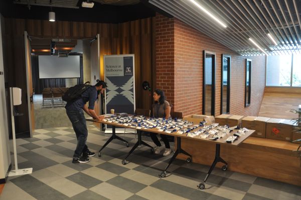 A conference attendee registering, with the desk staffed by a summit organiser