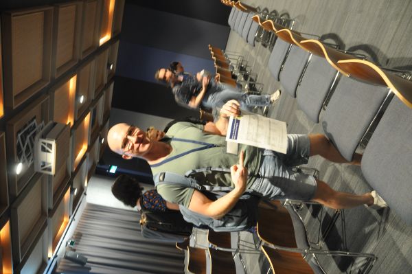 Several conference attendees leaving a talk session, one pointing to a copy of the schedule