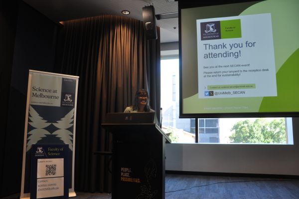 A speaker at the podium next to a slide reading 'Thank you for attending!'