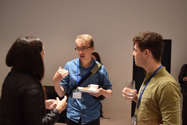 Several conference attendees holding plates and cups and talking