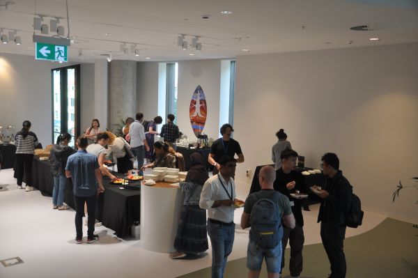 About twenty conference attendees talking and eating in the break area