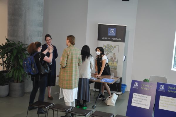 Several conference attendees and library staff at the library booth
