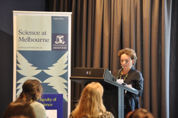 A close-up of the Dean of Science at the podium next to the 'Science at Melbourne' banner