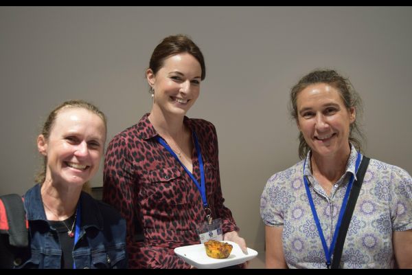 Several conference attendees, one holding a plate of food