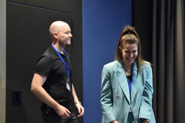 Two conference attendees standing in a presentation room