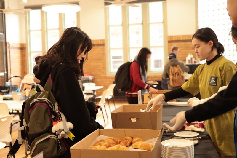 Student picking up a croissant 