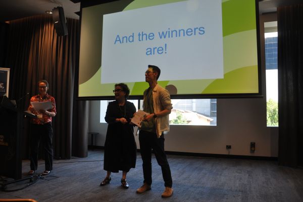 The Dean of Science presenting a certificate to a speaker in front of a slide reading 'And the winners are!'