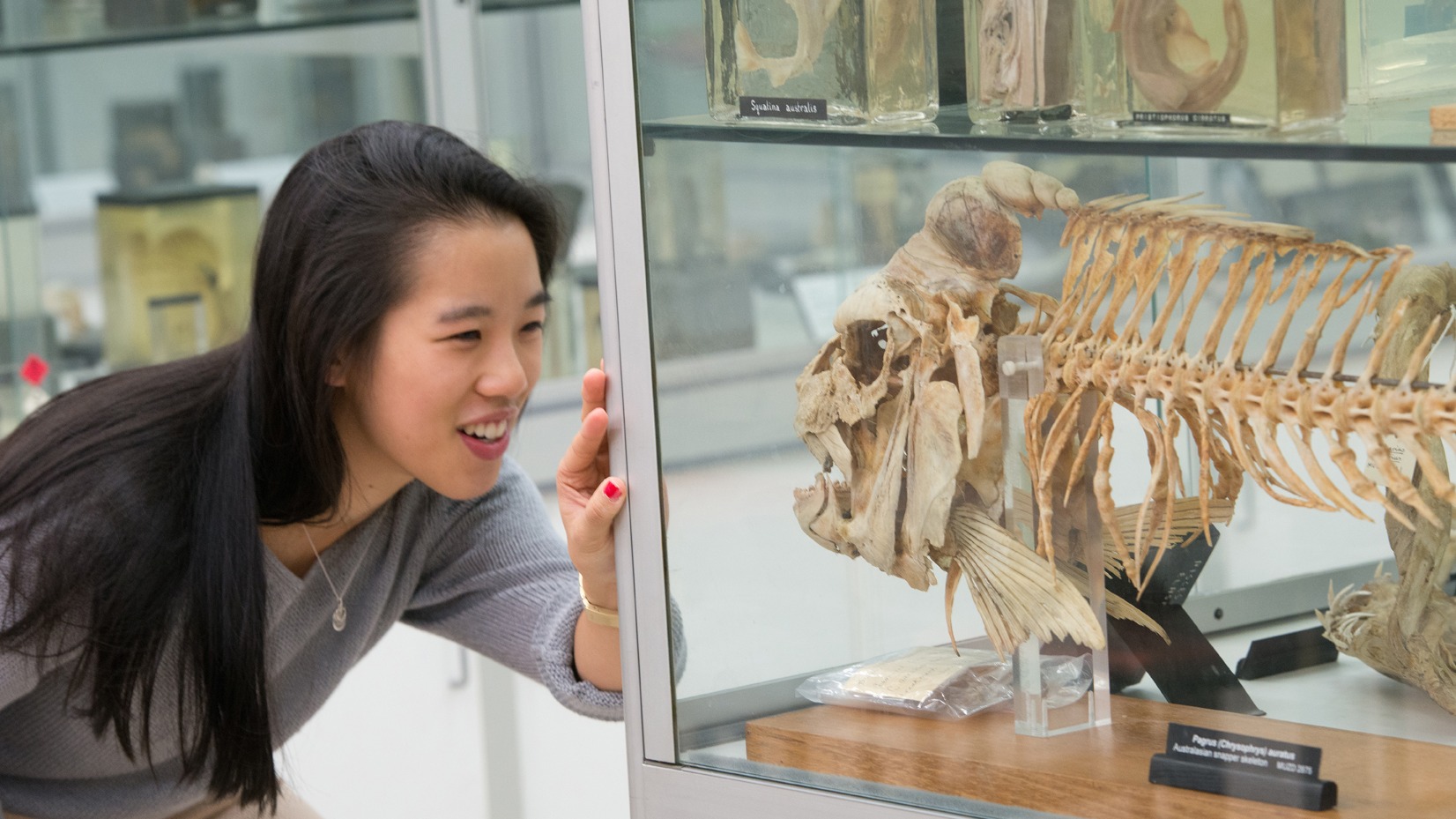 Image of Cindy Nguyen looking at fish skeleton