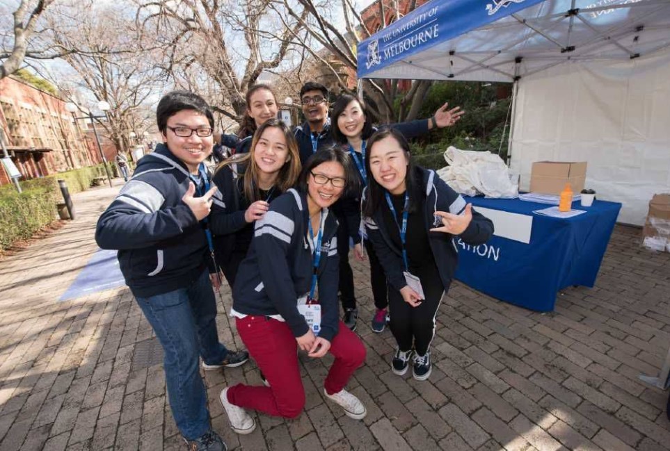 Group of young people posing in front of information booth
