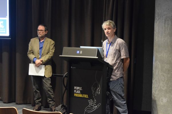 A conference presenter at the podium