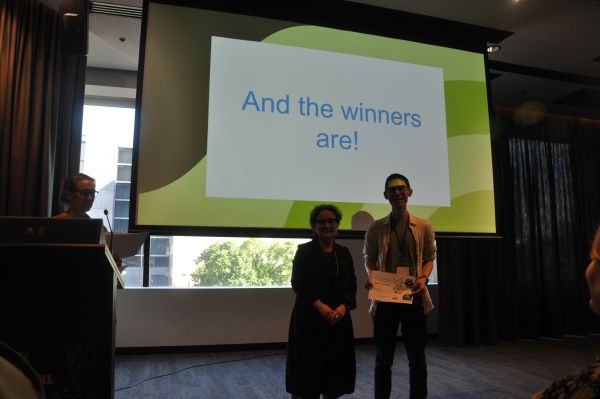 The Dean of Science presenting a certificate to a speaker in front of a slide reading 'And the winners are!'