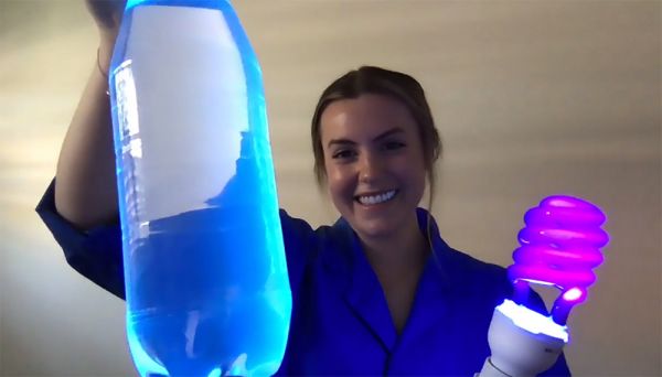 Courtney, with a purple light bulb and a bottle of glowing water