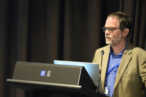 A close-up of a conference presenter at the podium