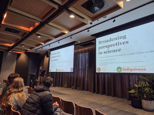 A photo of the plenary presentation - the talk's title, 'Broadening perspectives in science', is visible on the slide